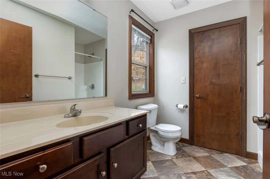 Full bathroom with vanity, stone finish floors, and a shower