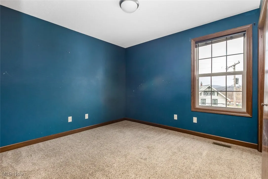 Spare room with carpet and baseboards