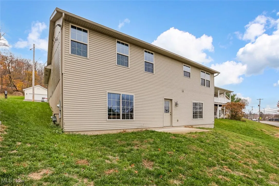 Back of property with a patio, a yard, and a balcony