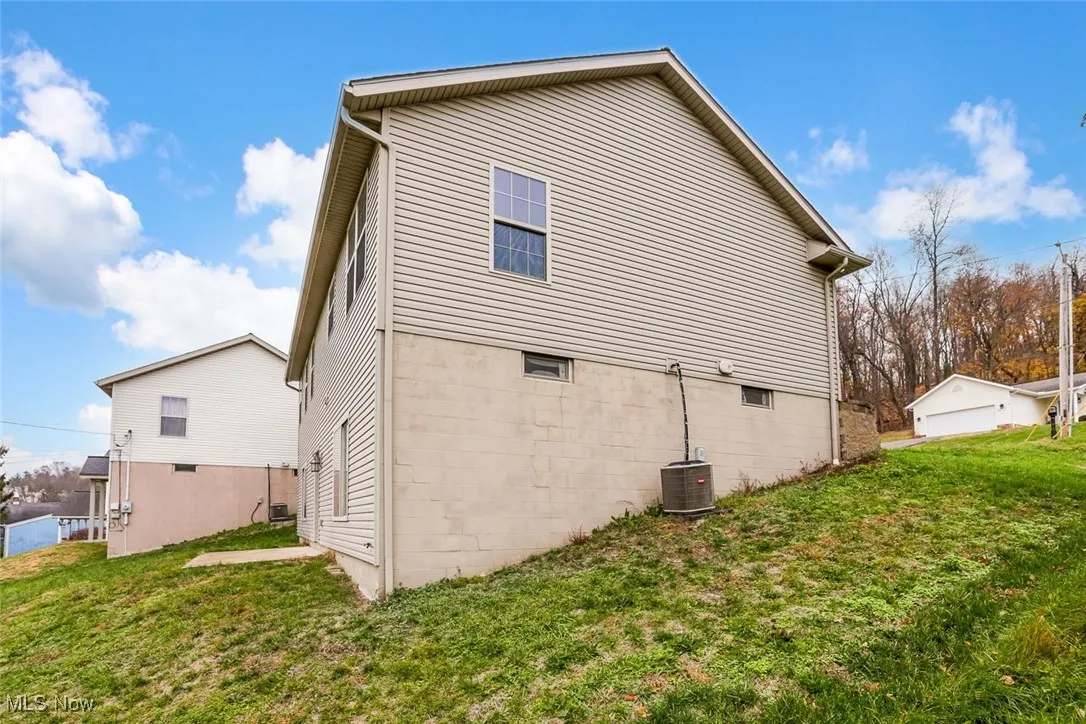 View of property exterior featuring a lawn and a garage