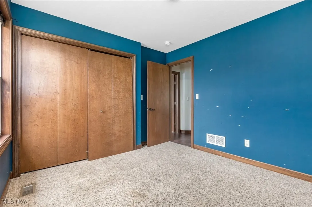 Unfurnished bedroom with a closet and carpet flooring