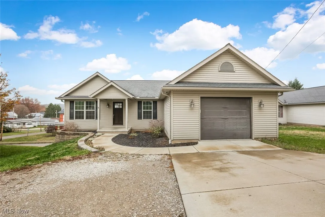 Ranch-style house featuring driveway, a shingled roof, and covered porch