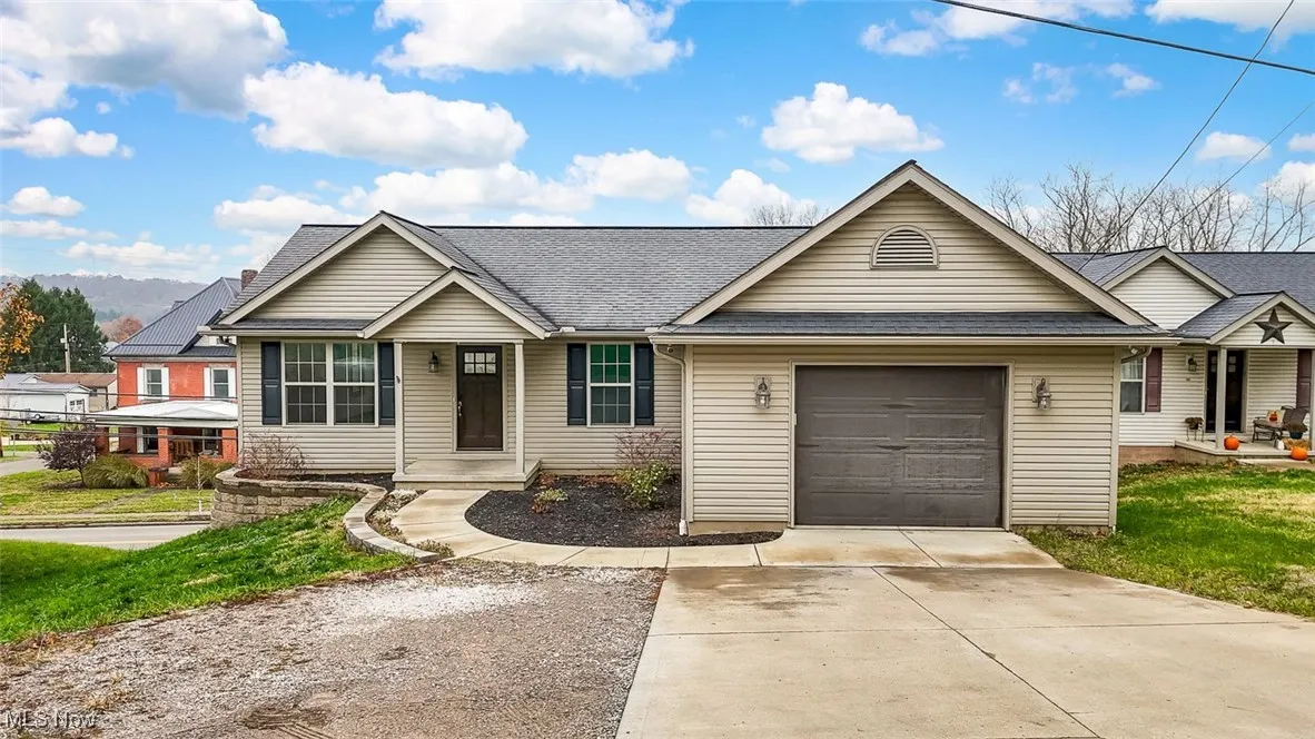 Single story home featuring roof with shingles, driveway, and an attached garage