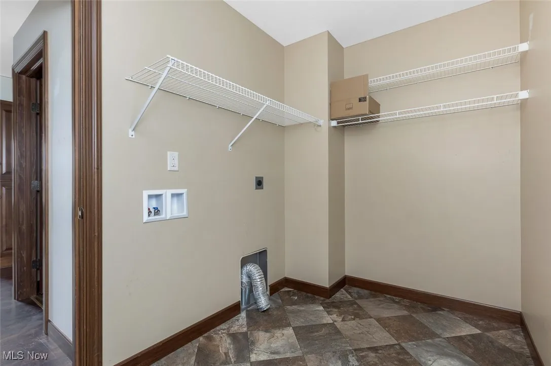 Laundry room with stone finish floors, electric dryer hookup, and hookup for a washing machine