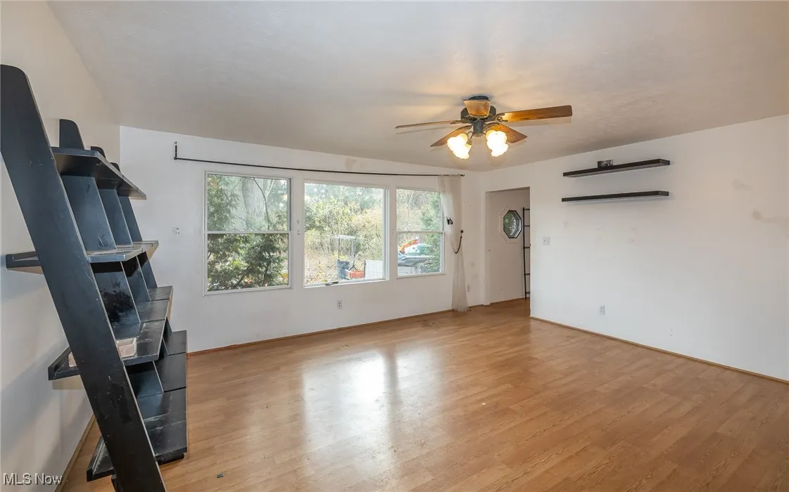 Unfurnished living room with light wood-style floors and ceiling fan