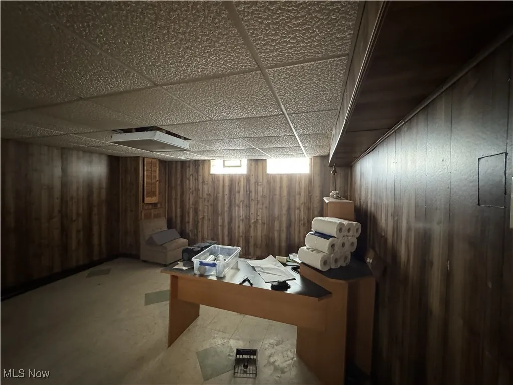 Below grade area with wood walls and a drop ceiling