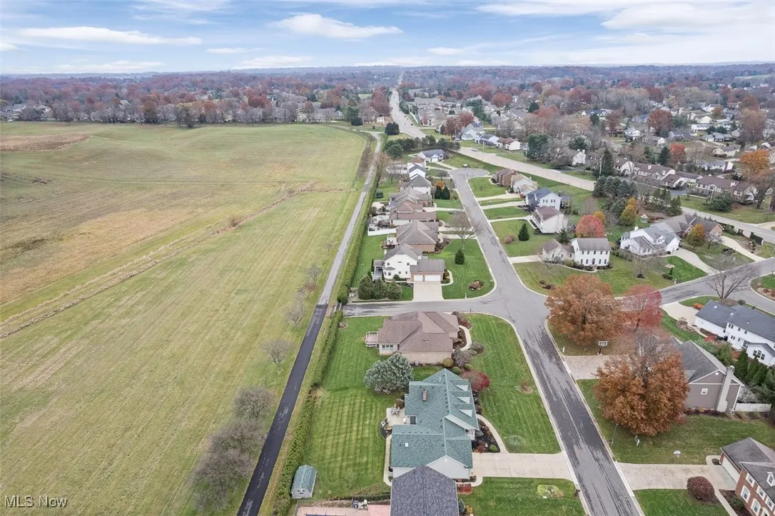 Aerial view of property and surrounding area with nearby suburban area