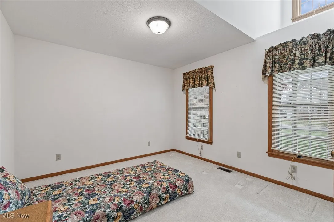 Bedroom featuring carpet and a textured ceiling