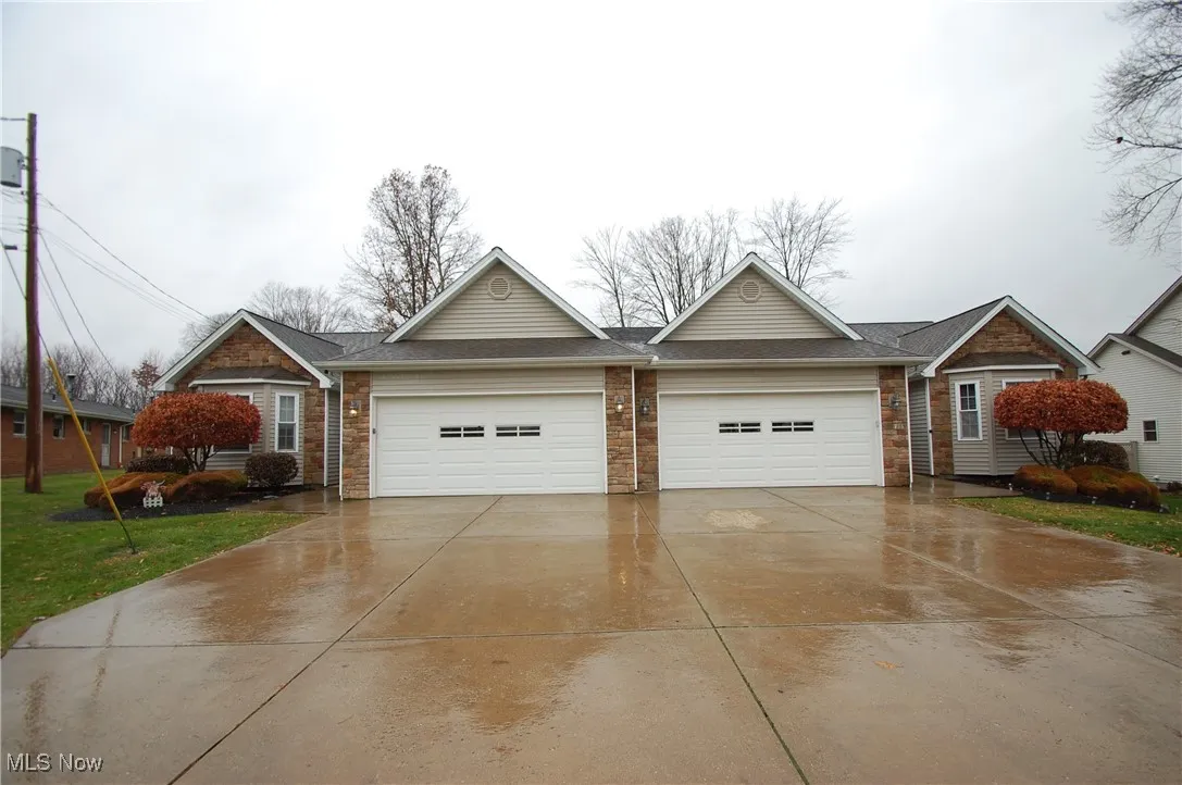Single story home with driveway, a shingled roof, an attached garage, and a front yard