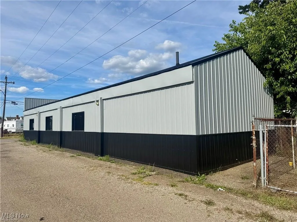 View of home's exterior featuring an outdoor structure and a pole building