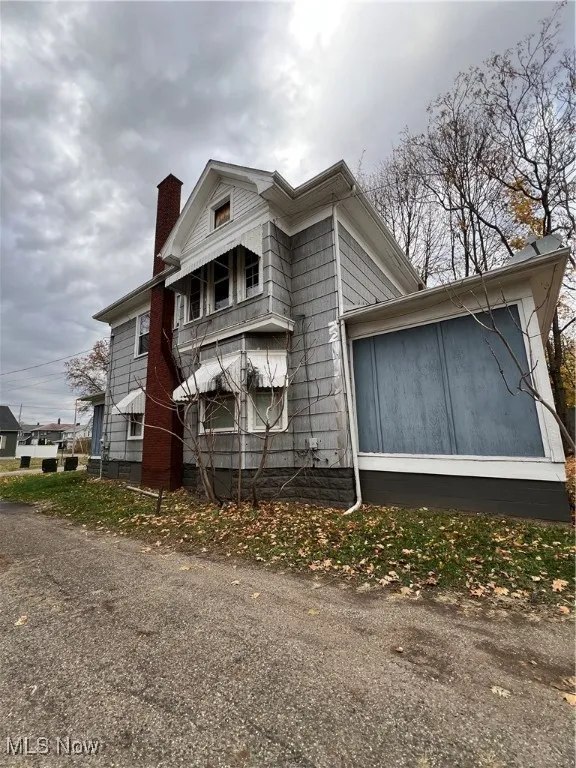 View of property exterior featuring a chimney