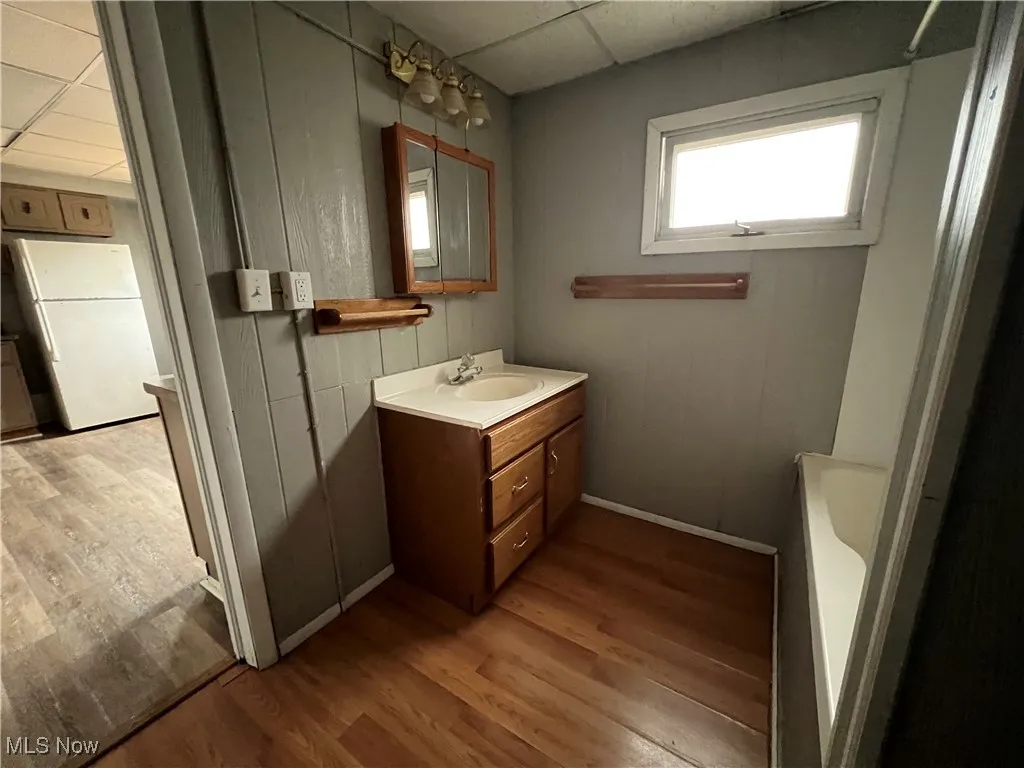 Bathroom with dark wood-style flooring, a paneled ceiling, and vanity