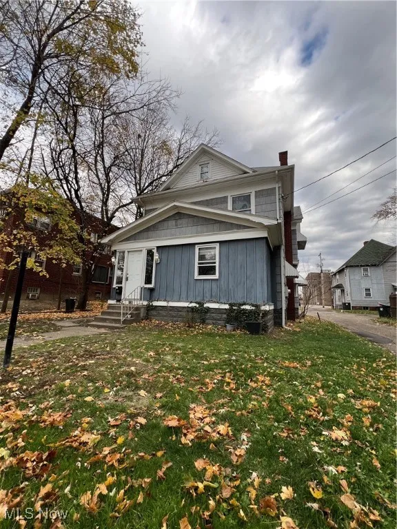 View of front of property with a chimney and a front yard