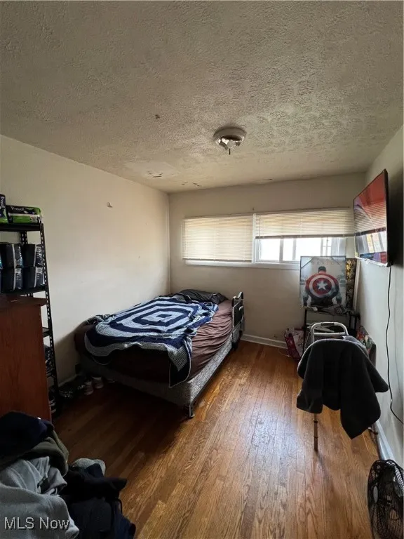 Bedroom featuring hardwood / wood-style floors and a textured ceiling