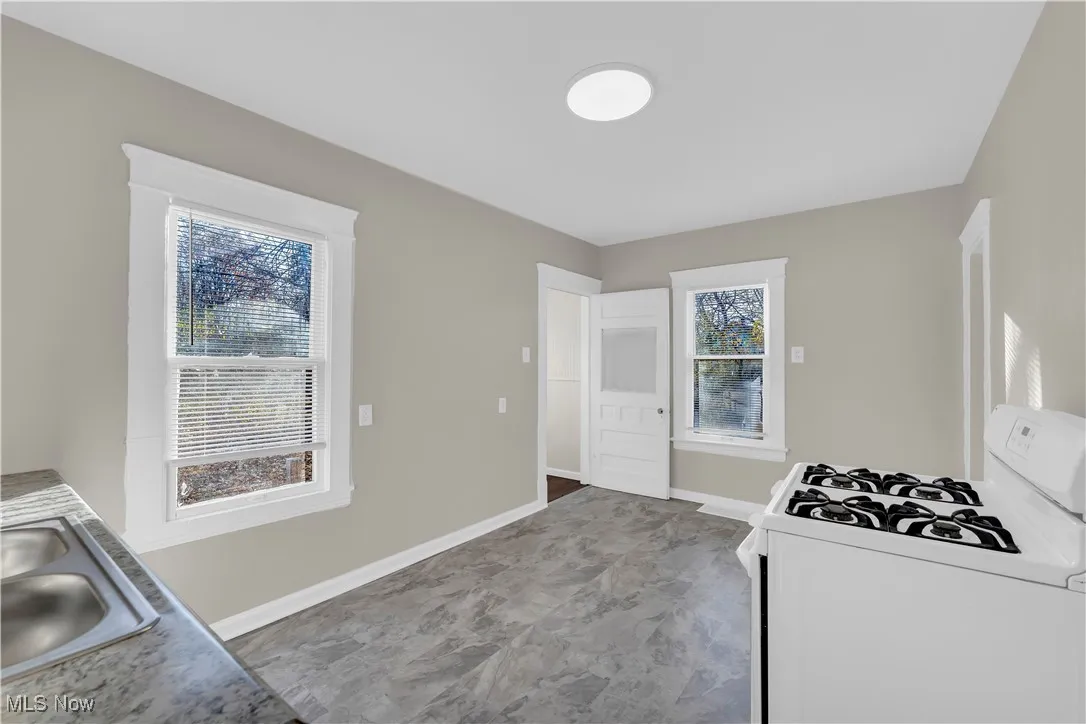 Kitchen featuring white gas stove and a sink