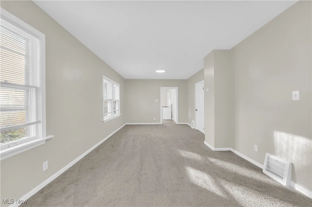 Empty room with carpet flooring and baseboards