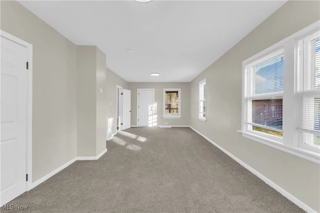 Carpeted empty room featuring baseboards