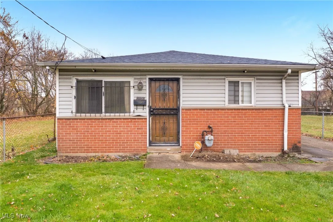 View of front of house featuring brick siding and a shingled roof