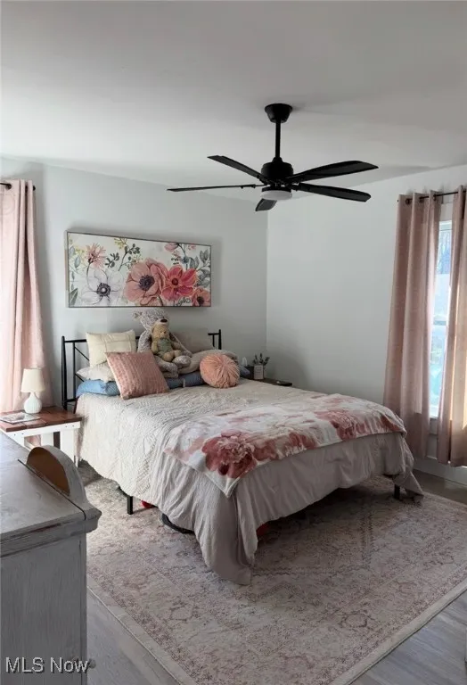 Bedroom with a ceiling fan and wood finished floors