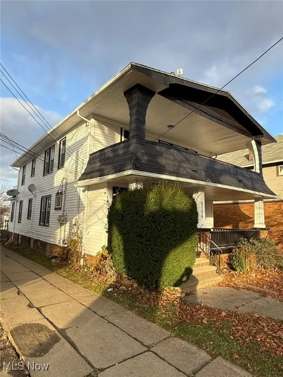 View of side of home with a balcony and covered porch