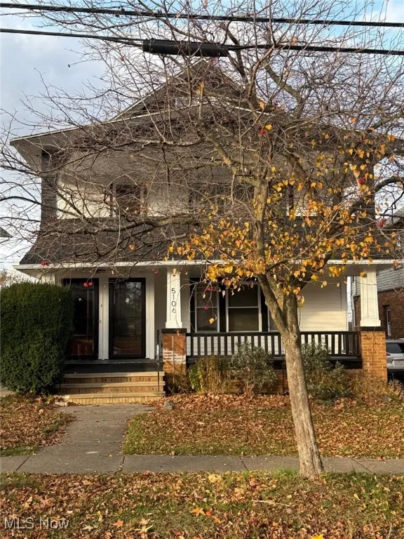 View of front facade with covered porch and brick siding