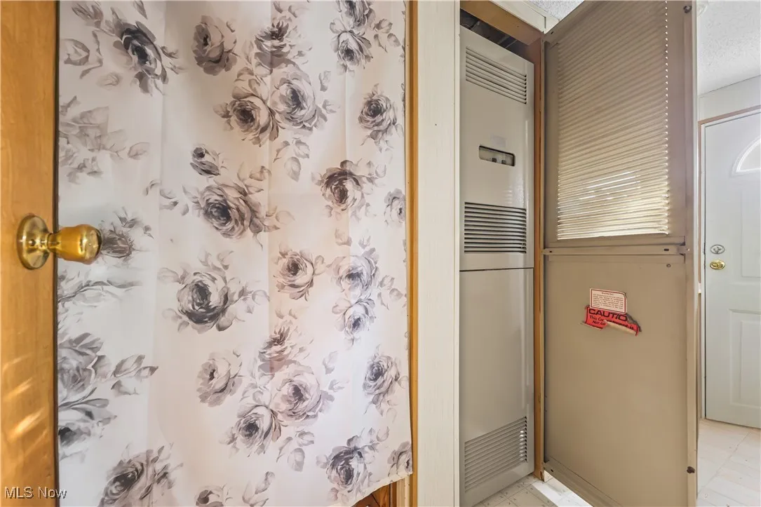 Full bath featuring a shower with shower curtain, a heating unit, and a skylight