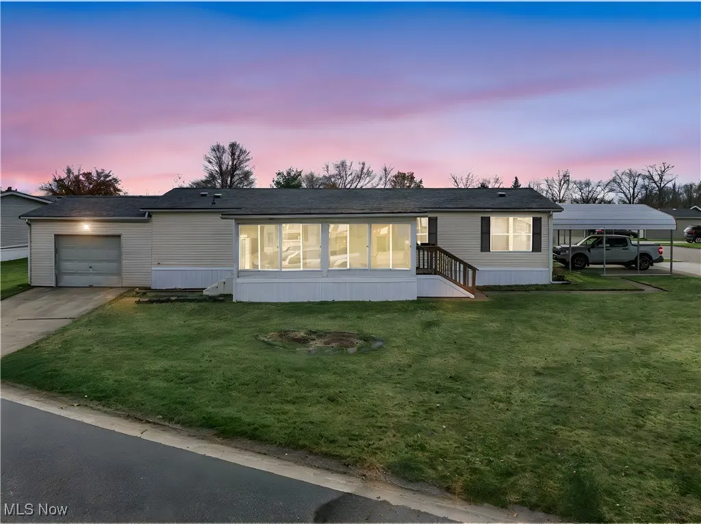 Manufactured / mobile home featuring a front lawn and driveway