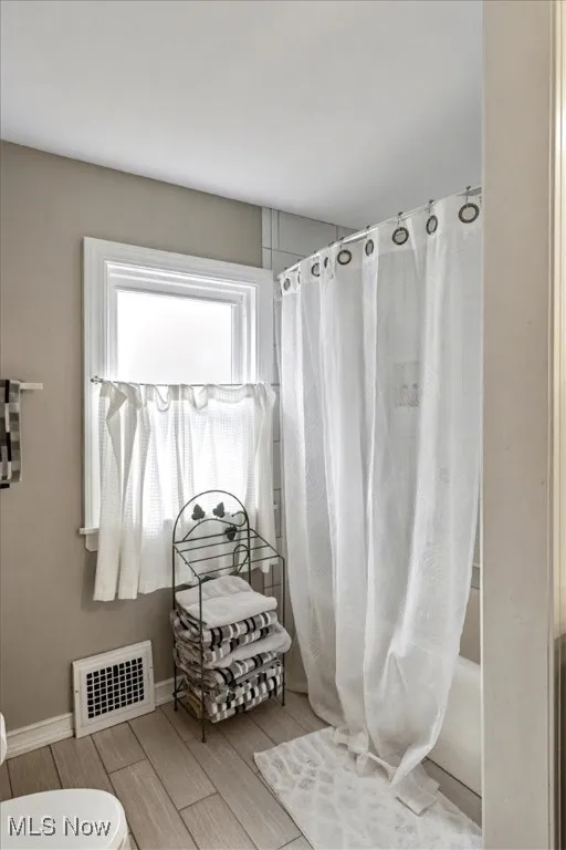 Bathroom with wood tiled floors and baseboards