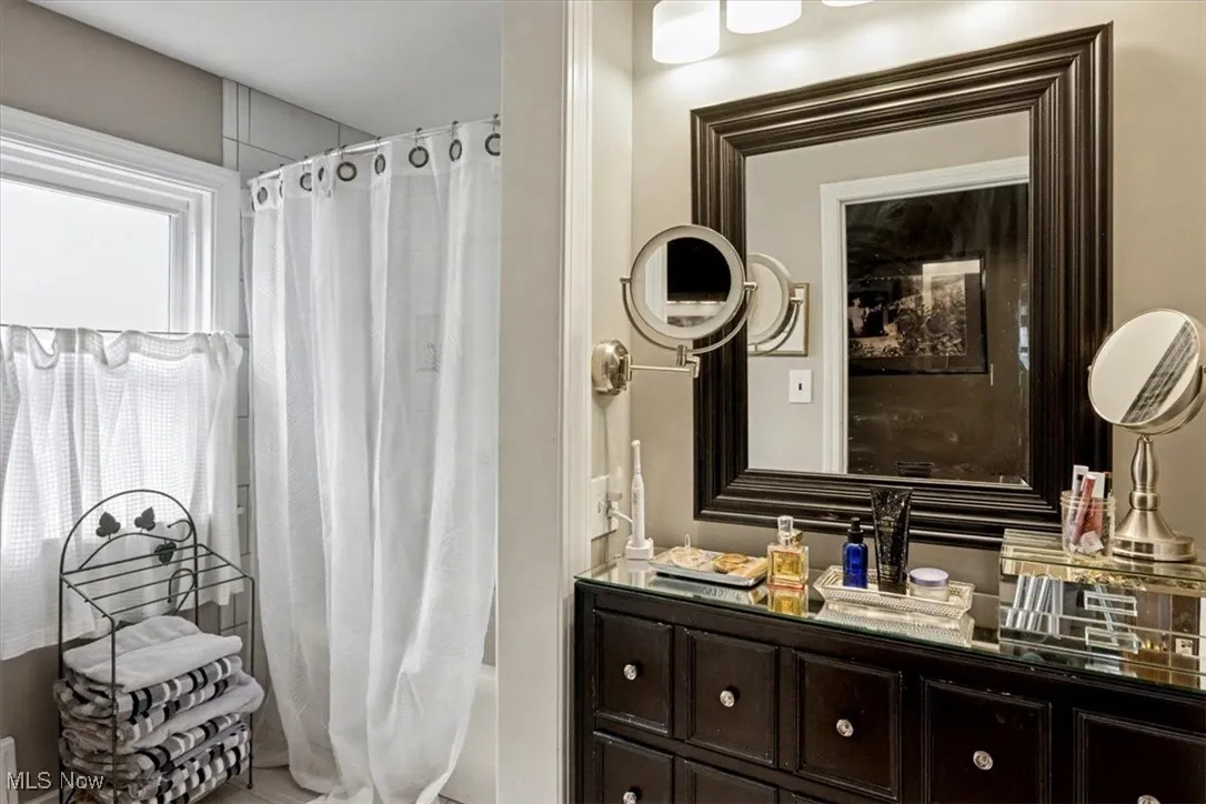 Full bathroom with vanity and shower / bathtub combination with curtain