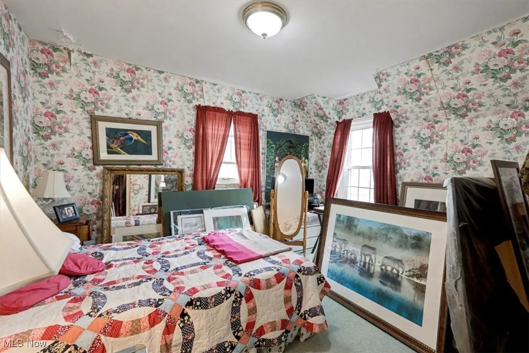 Carpeted bedroom featuring wallpapered walls