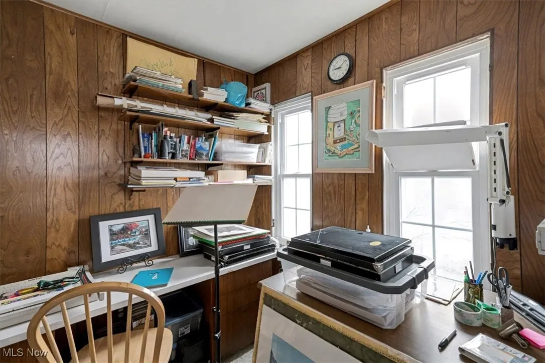 Miscellaneous room with wood walls and a desk