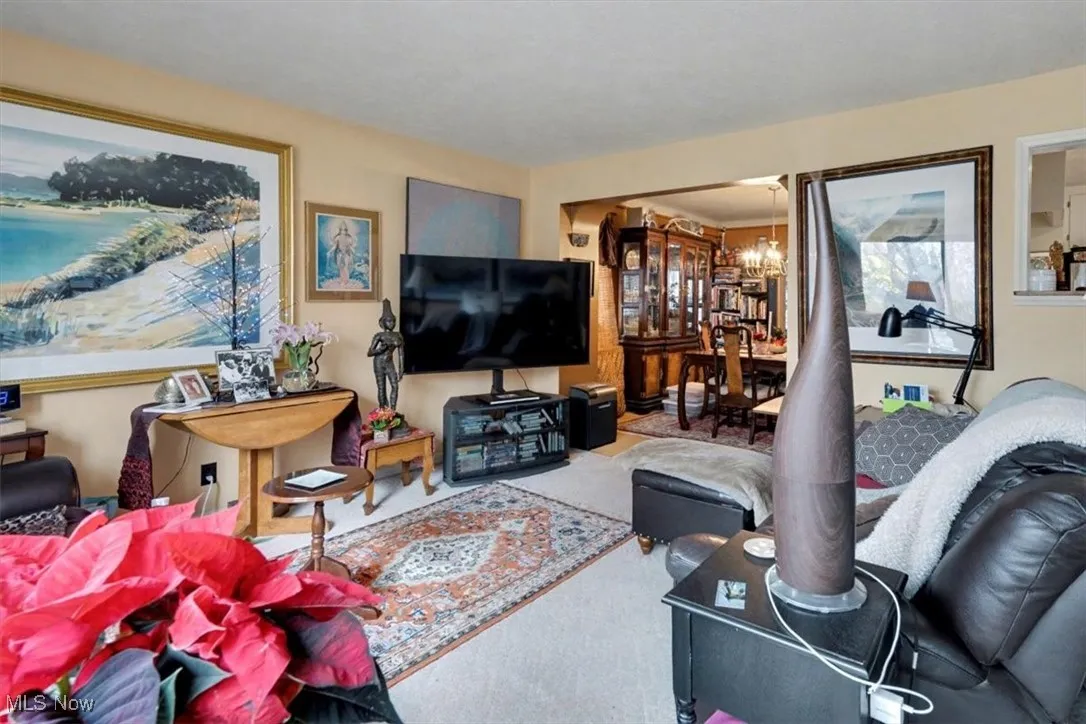 Carpeted living room with a chandelier