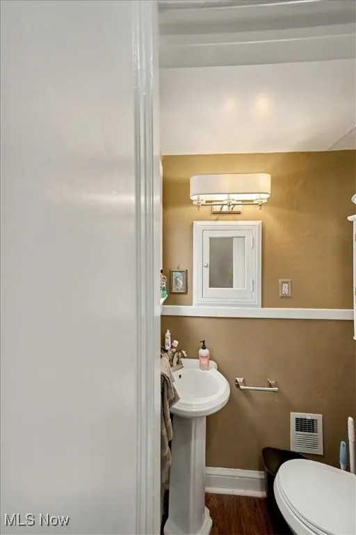 Bathroom with toilet and dark wood-style flooring