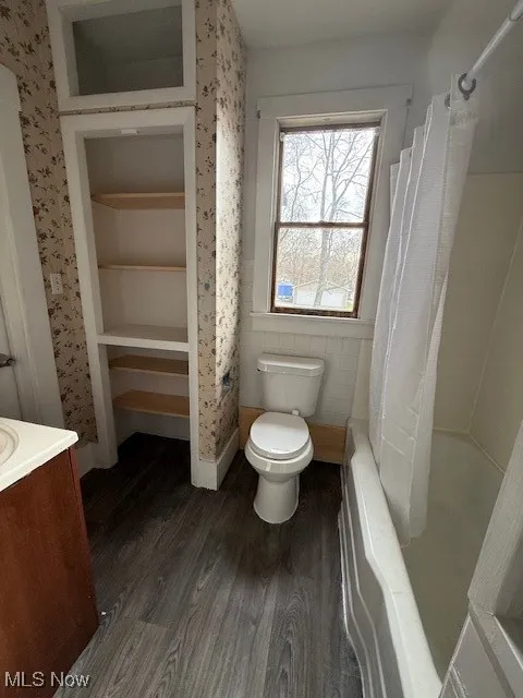 Full bathroom with vanity, dark wood finished floors, and shower / tub combo with curtain 1st floor unit