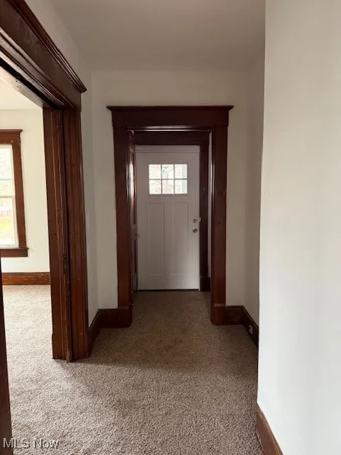Entry way downstairs unit featuring baseboards and carpet flooring