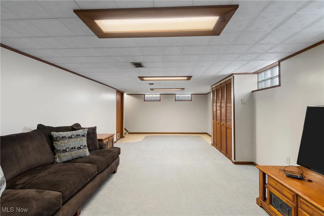 Living area with light carpet and crown molding