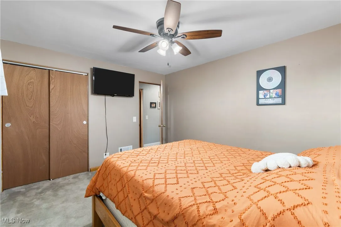 Bedroom with carpet flooring, a closet, and ceiling fan