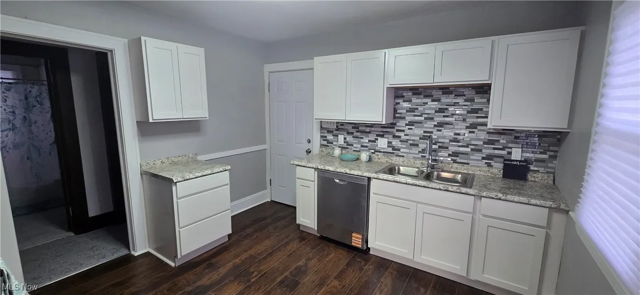 2nd level Kitchen with white cabinetry, stainless steel dishwasher, tasteful backsplash, and dark wood-style flooring