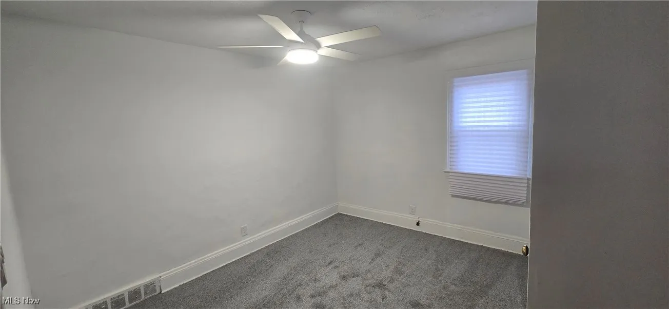 2nd level bedroom 1 featuring dark carpet and a ceiling fan