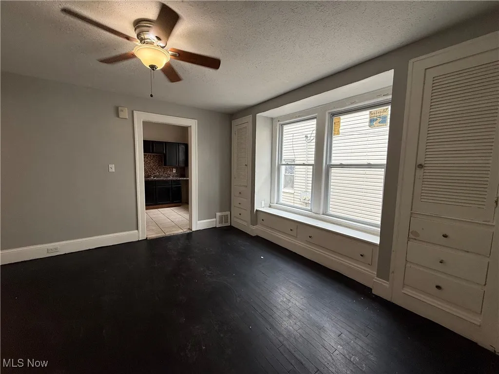 Unfurnished room featuring a textured ceiling, ceiling fan, and wood-type flooring