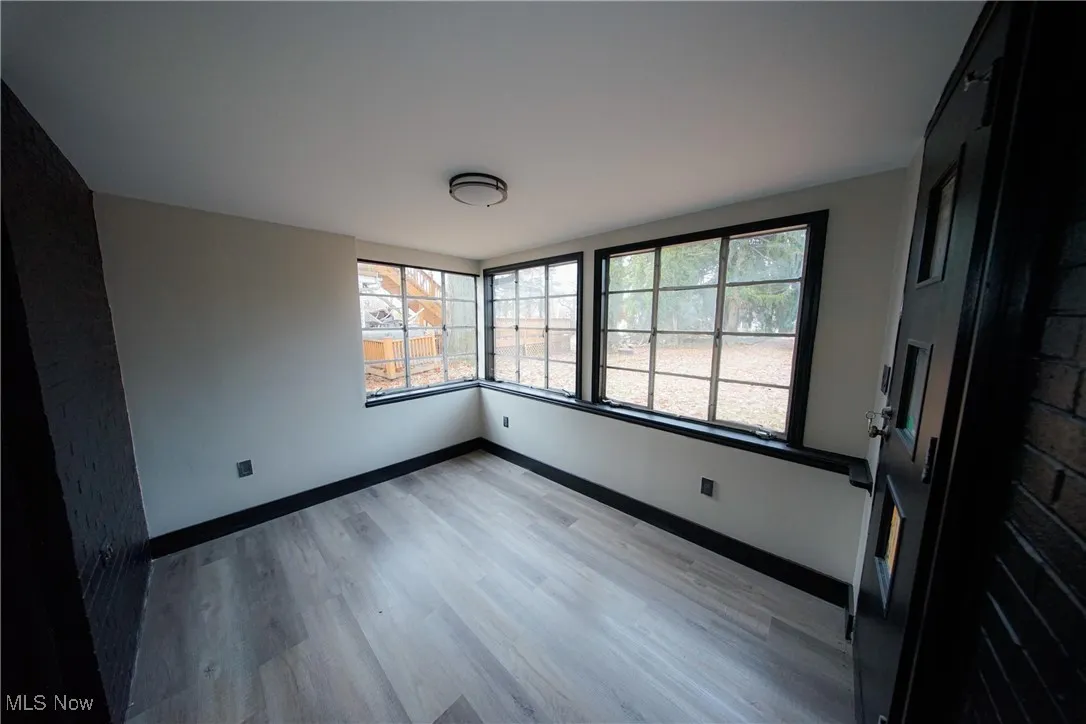 Empty room featuring baseboards and light wood-style flooring