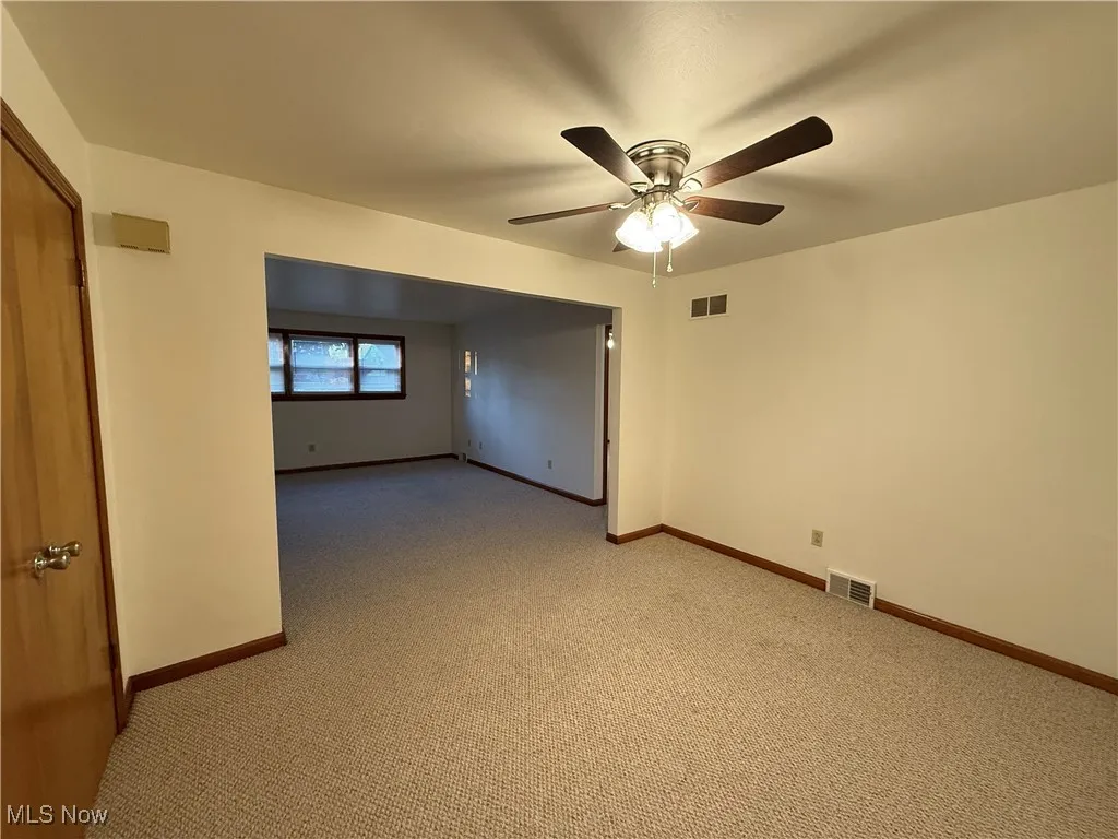 Spare room with carpet floors and ceiling fan