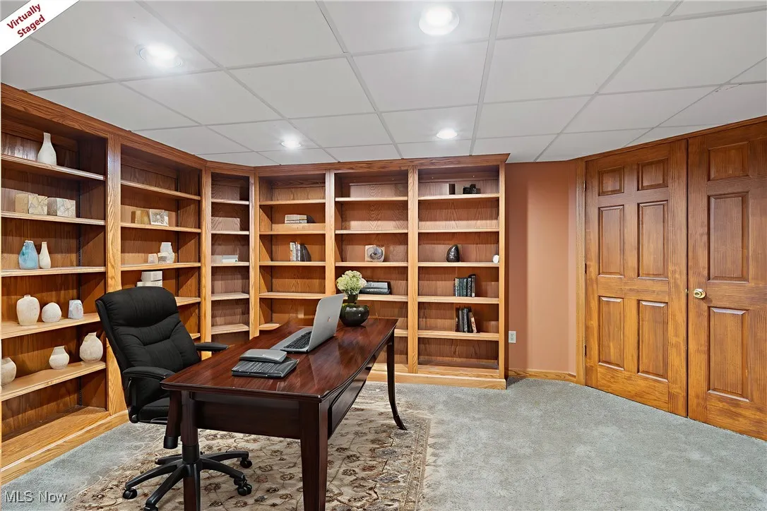 Home office featuring light carpet, a drop ceiling, recessed lighting, and built in shelves
