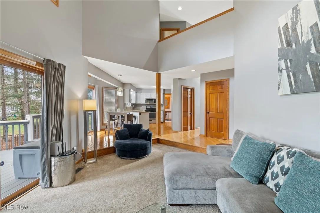 Carpeted living room featuring a high ceiling and recessed lighting