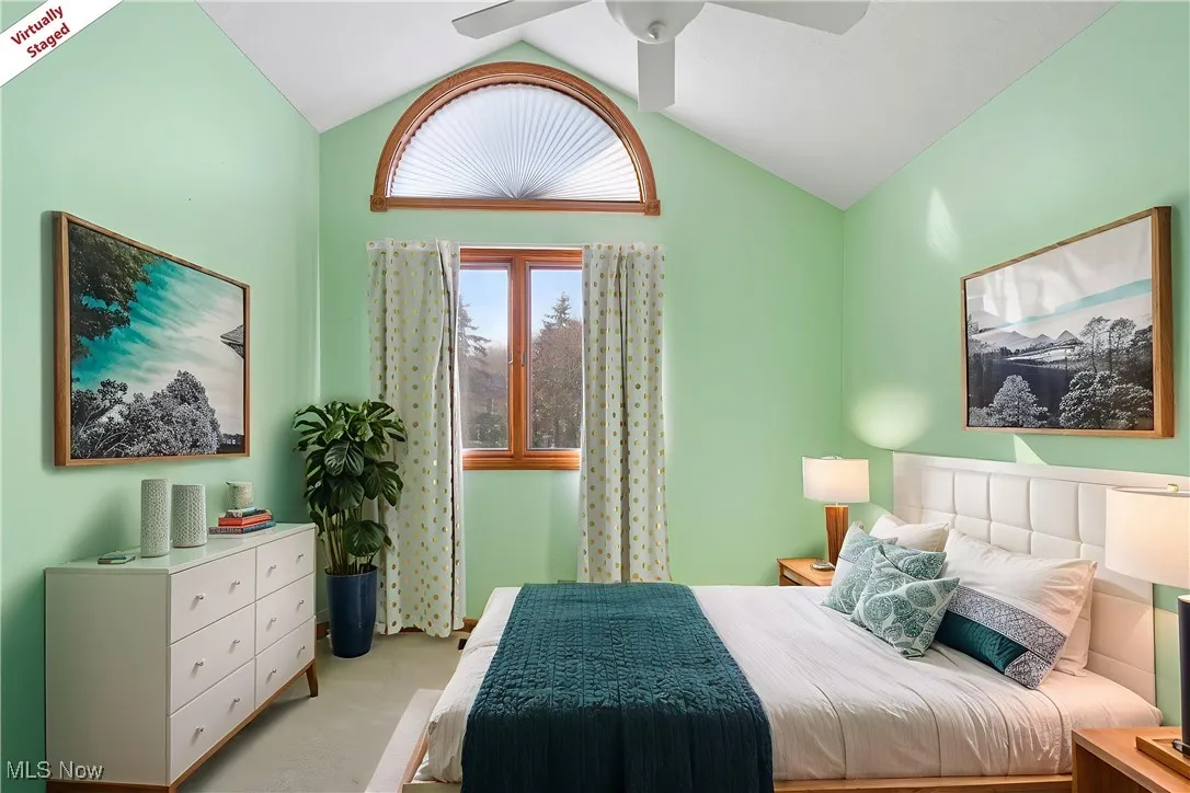 Carpeted bedroom with lofted ceiling and a ceiling fan
