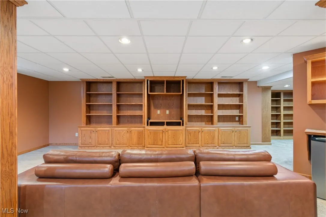 Unfurnished living room featuring built in features, recessed lighting, and a drop ceiling