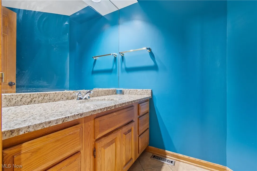 Half bath with vanity and light tile patterned floors