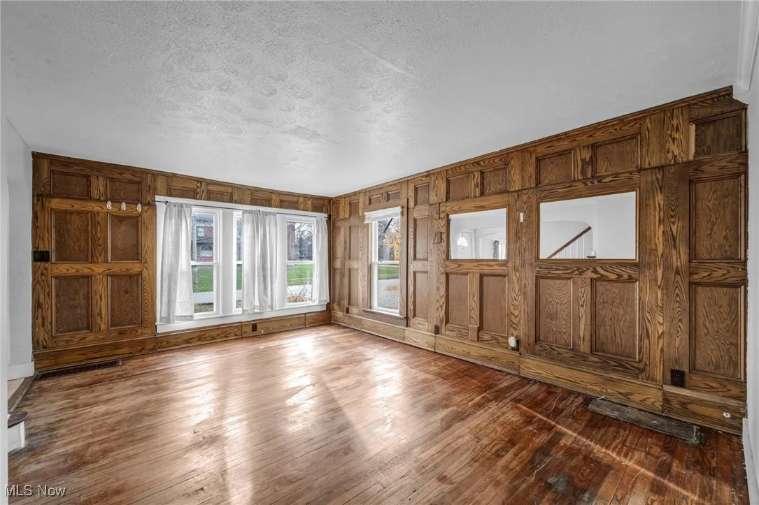 Unfurnished living room featuring a textured ceiling and hardwood / wood-style flooring