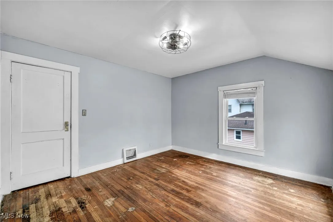 Bonus room featuring dark wood-style floors and lofted ceiling