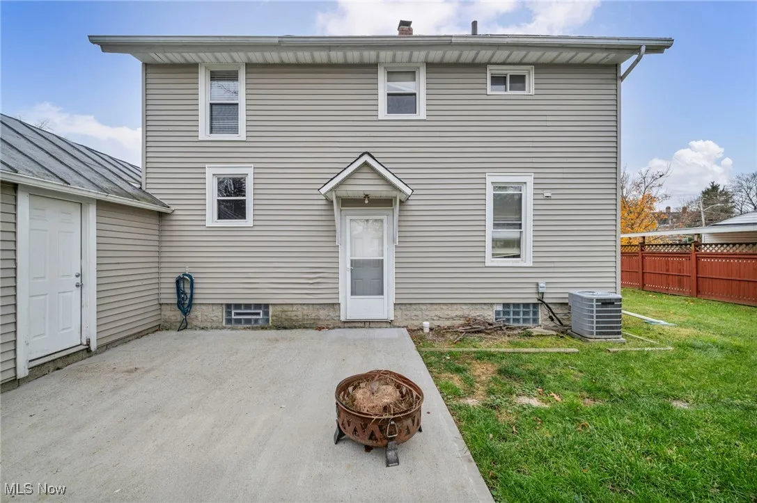 Back of property featuring a patio area, an outdoor fire pit, and a standing seam roof
